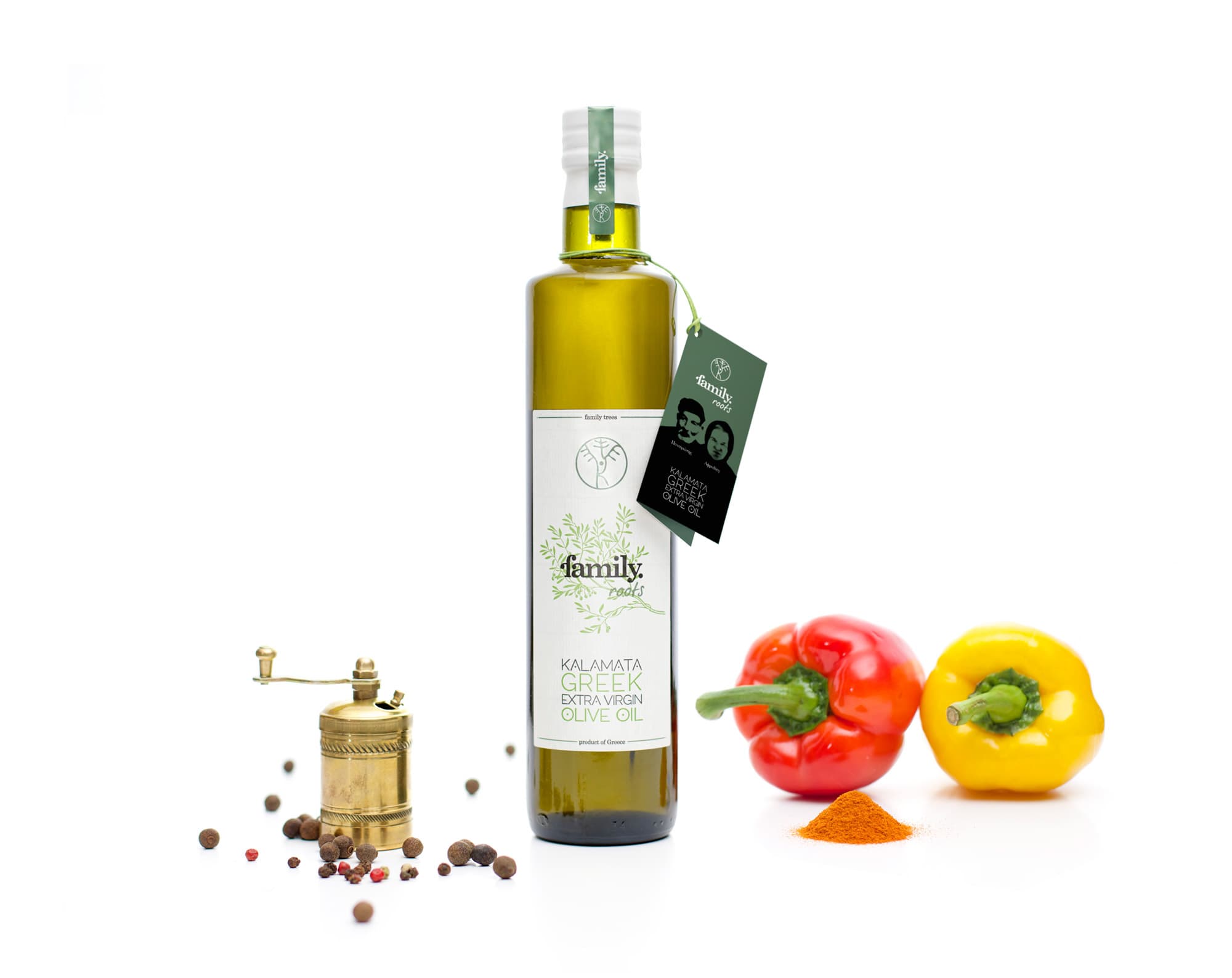 Botella de aceite de oliva family. roots de 500 ml junto a pimientos rojos y amarillos
